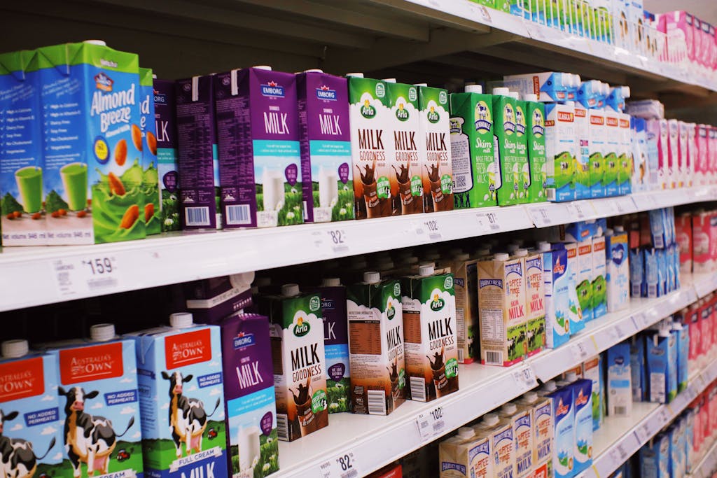 Assorted milk cartons on bright supermarket shelves.